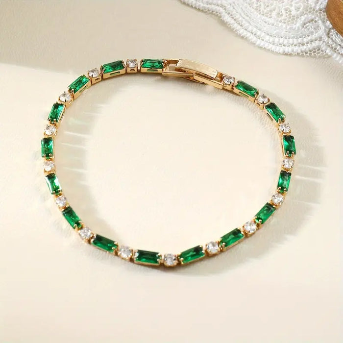 Pulsera de tenis alternante esmeralda dorada