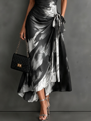 Vestido midi cruzado con estampado abstracto rojo y negro, escote en V, mangas cortas, cinturón y bajo asimétrico con volantes