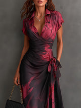 Vestido midi cruzado con estampado abstracto rojo y negro, escote en V, mangas cortas, cinturón y bajo asimétrico con volantes