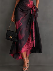 Vestido midi cruzado con estampado abstracto rojo y negro, escote en V, mangas cortas, cinturón y bajo asimétrico con volantes